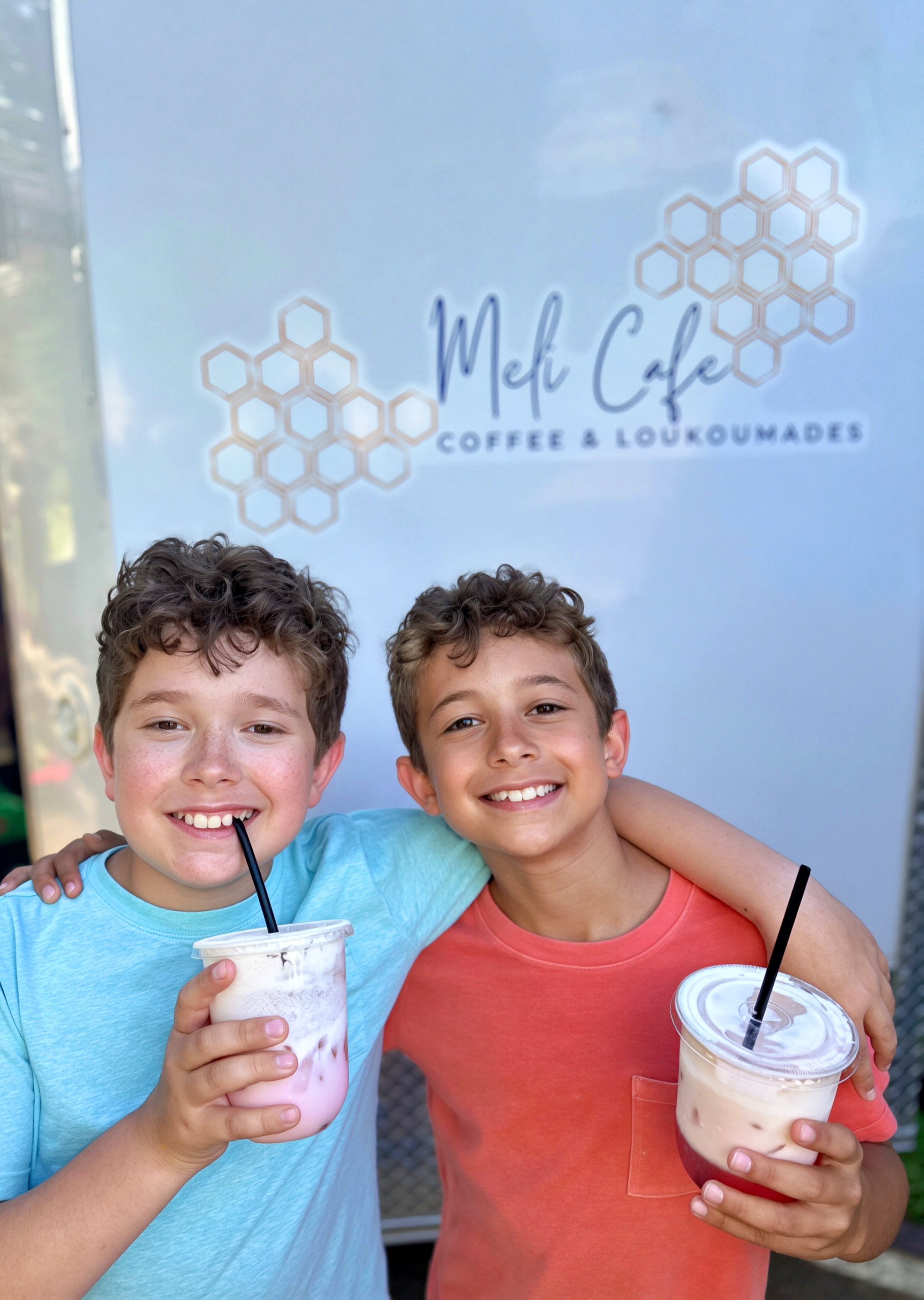 Kids with drinks in front of logo